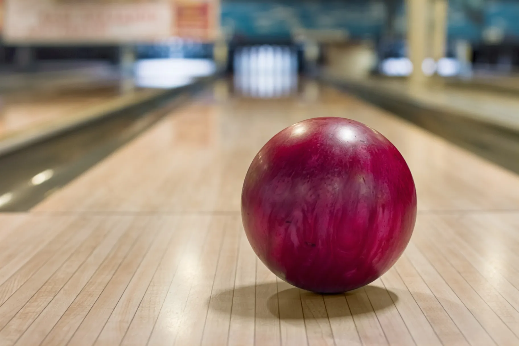 Red bowling ball on the track in the game center Red bowling ball on the track in the game center